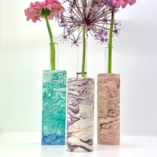 Høje vaser med reagensglas og blomster